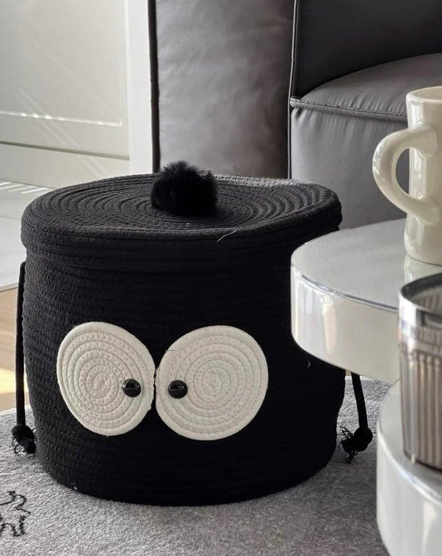 A cute woven laundry storage basket featuring a coal ball design with big eyes, perfect for kids' rooms and playful spaces.