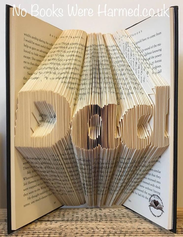 Hand-folded book art piece spelling 'Dad', crafted from vintage books, showcasing unique folds and textures.