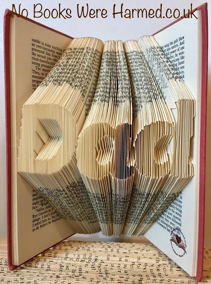 Hand-folded book art piece spelling 'Dad', crafted from vintage books, showcasing unique folds and textures.