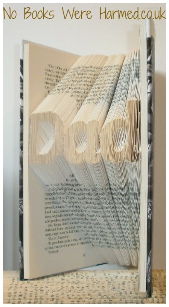 Hand-folded book art piece spelling 'Dad', crafted from vintage books, showcasing unique folds and textures.