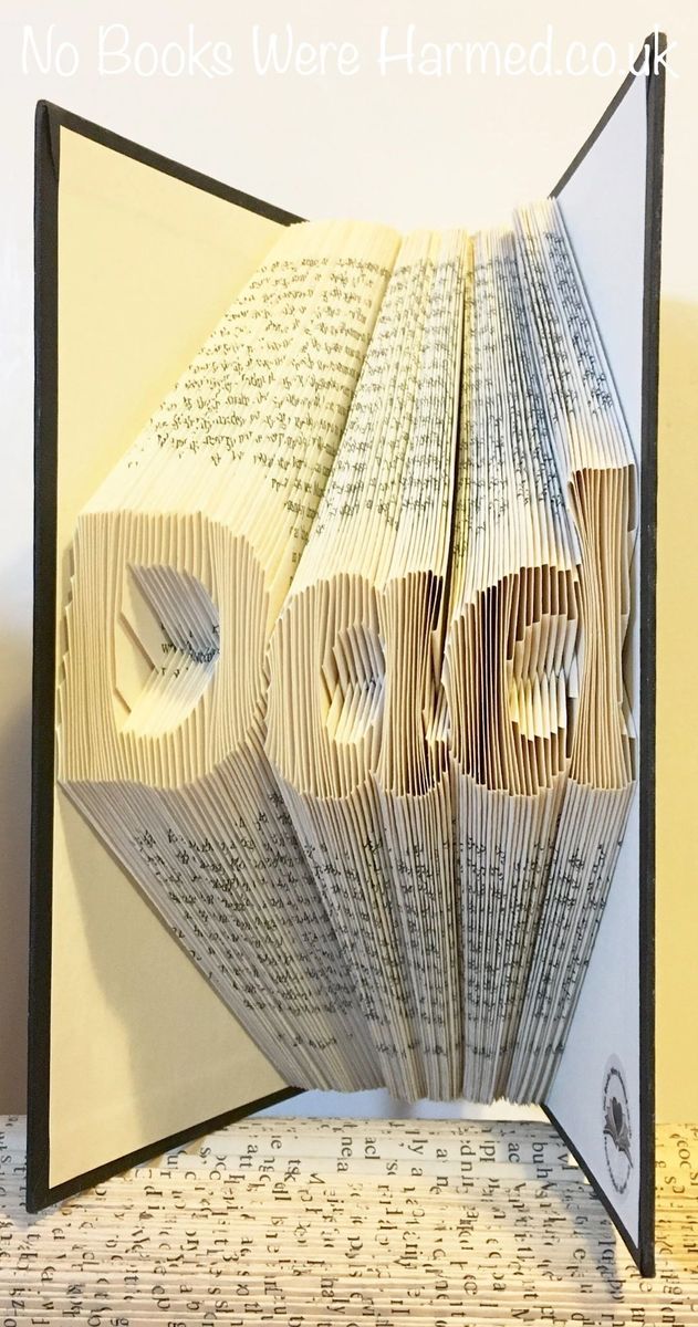 Hand-folded book art piece spelling 'Dad', crafted from vintage books, showcasing unique folds and textures.