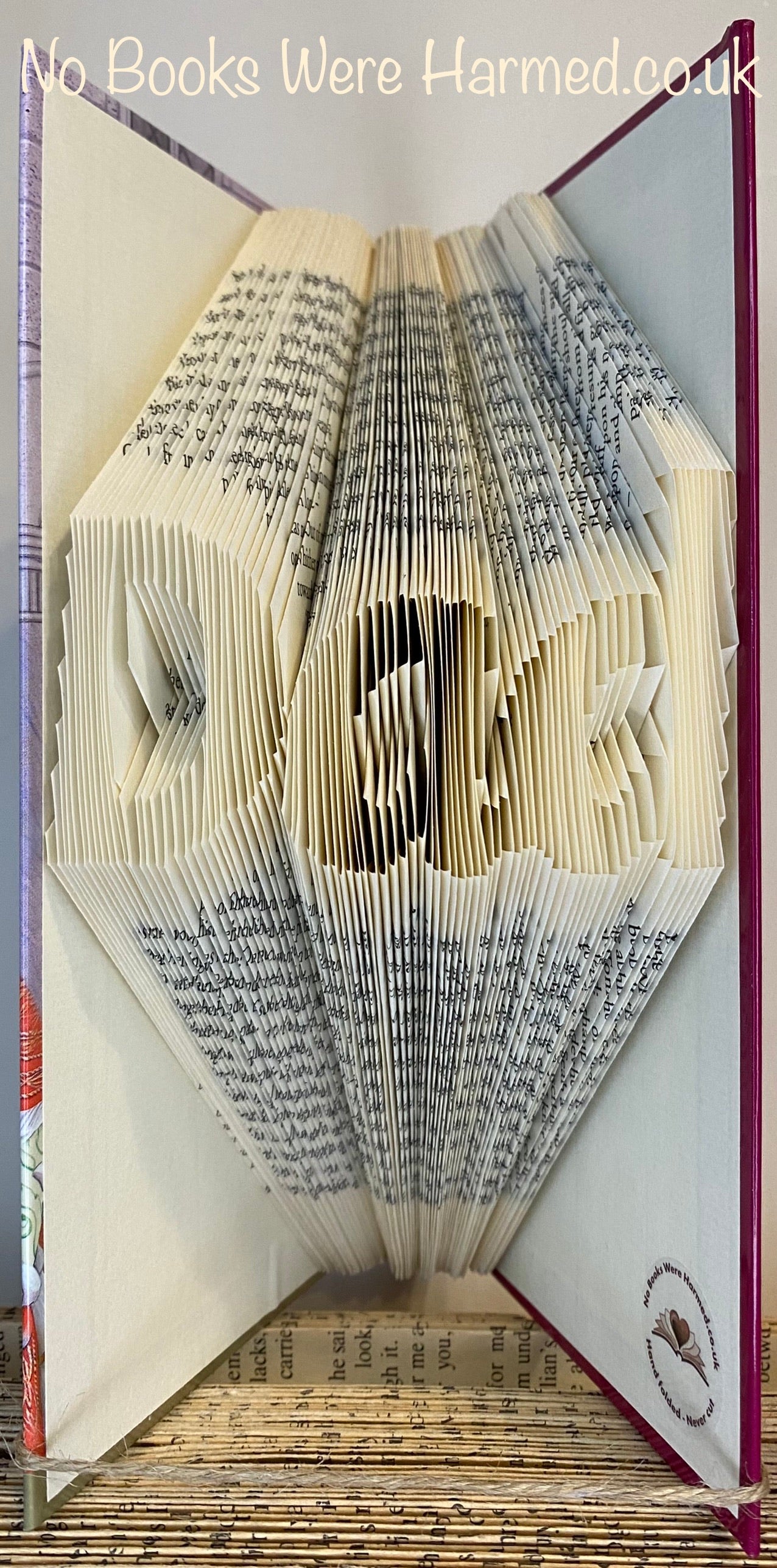 Hand-folded book art piece spelling 'Dad', crafted from vintage books, showcasing unique folds and textures.