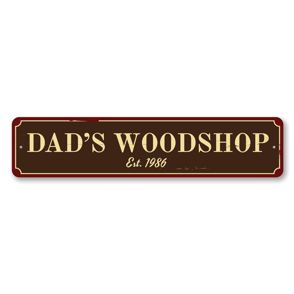 A decorative Dad's Woodshop Sign made of high-quality aluminum, featuring customizable text and pre-drilled holes for easy mounting.