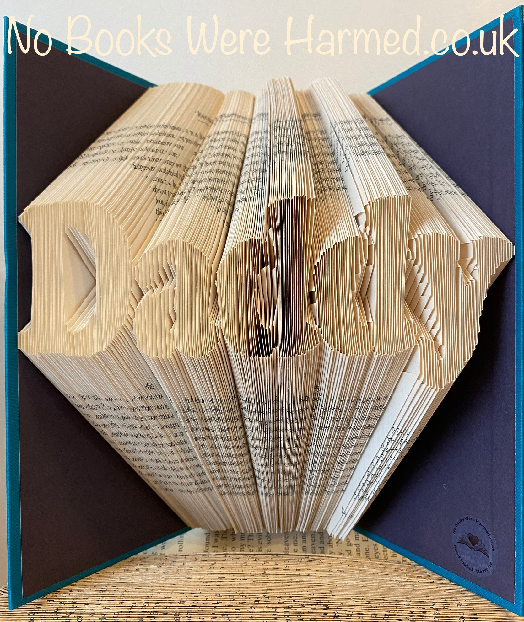 Handcrafted 'Daddy' art piece made from vintage books, showcasing unique folded pages and intricate design.