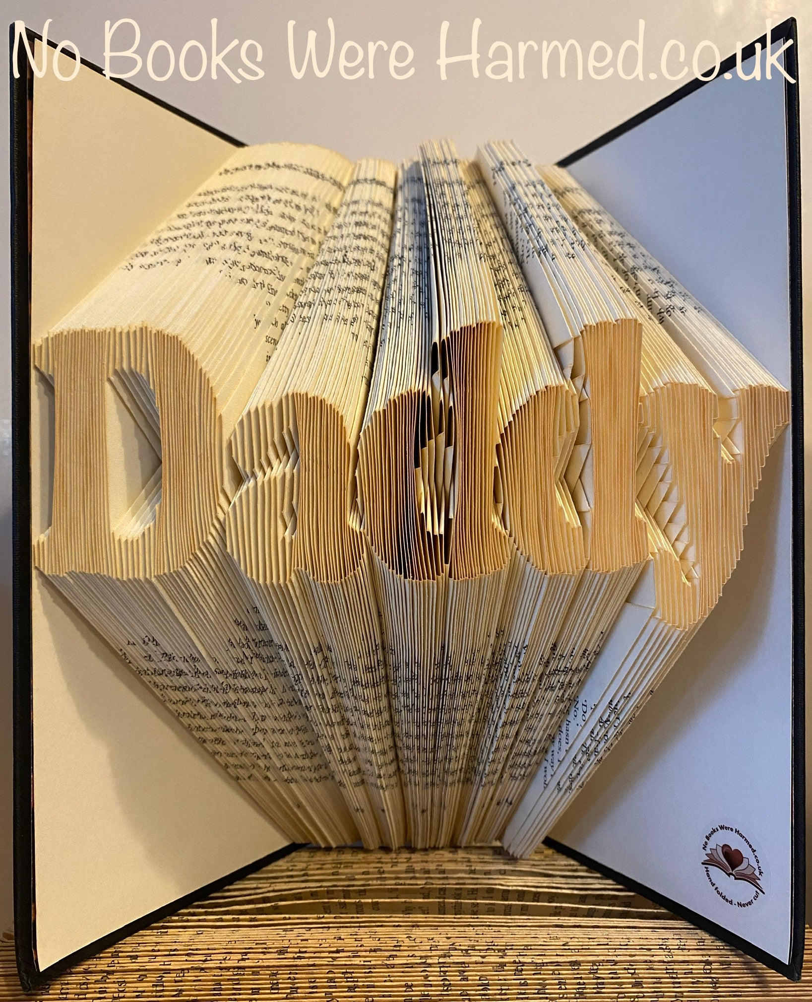 Handcrafted 'Daddy' art piece made from vintage books, showcasing unique folded pages and intricate design.