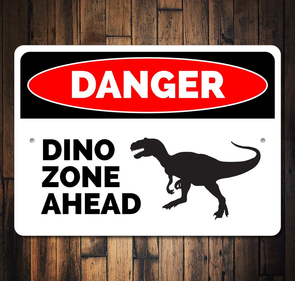 A colorful Danger Dino Zone Ahead Sign featuring playful dinosaur graphics, perfect for children's rooms.