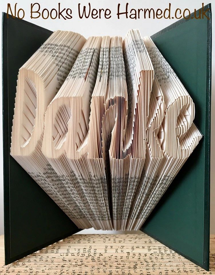 Hand-folded book art piece spelling 'Danke' in German, showcasing intricate page folds from a vintage book.