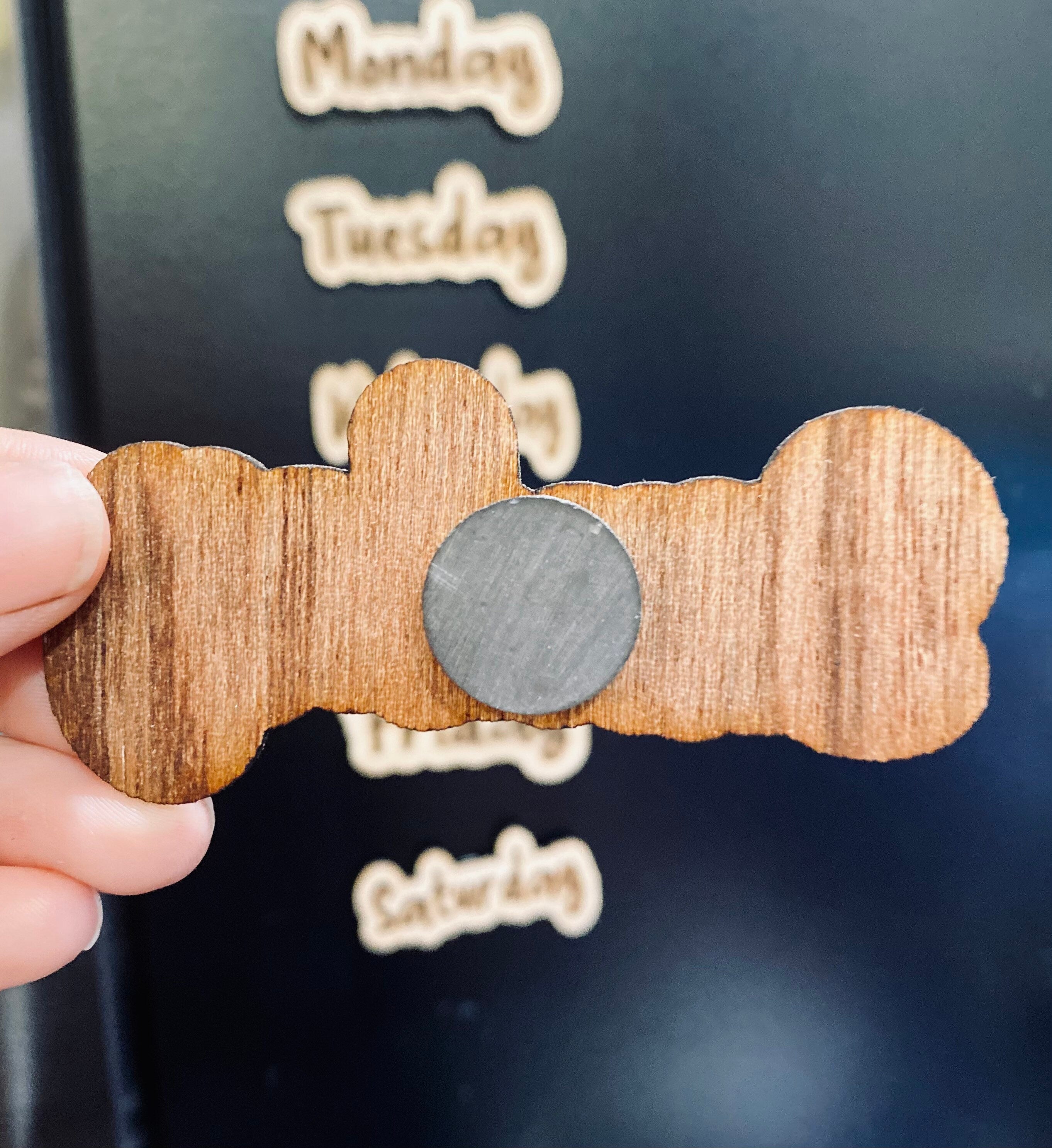 Set of wooden Days of the Week Magnets displayed on a fridge, showcasing their natural finish and laser engraved design.