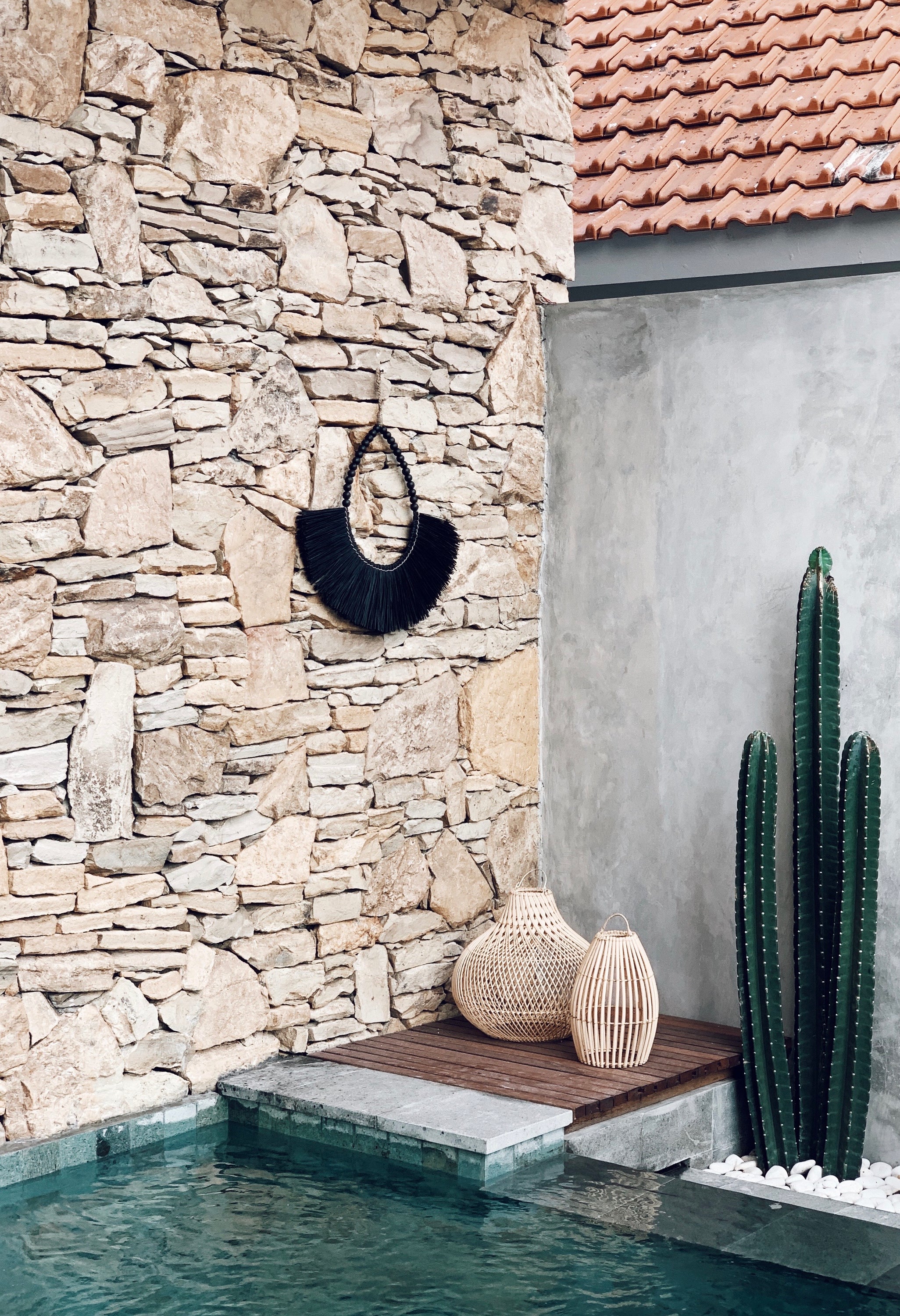 Baucau Allang wall decoration in black, featuring intricate grass weaving and decorative beads, perfect for bohemian decor.