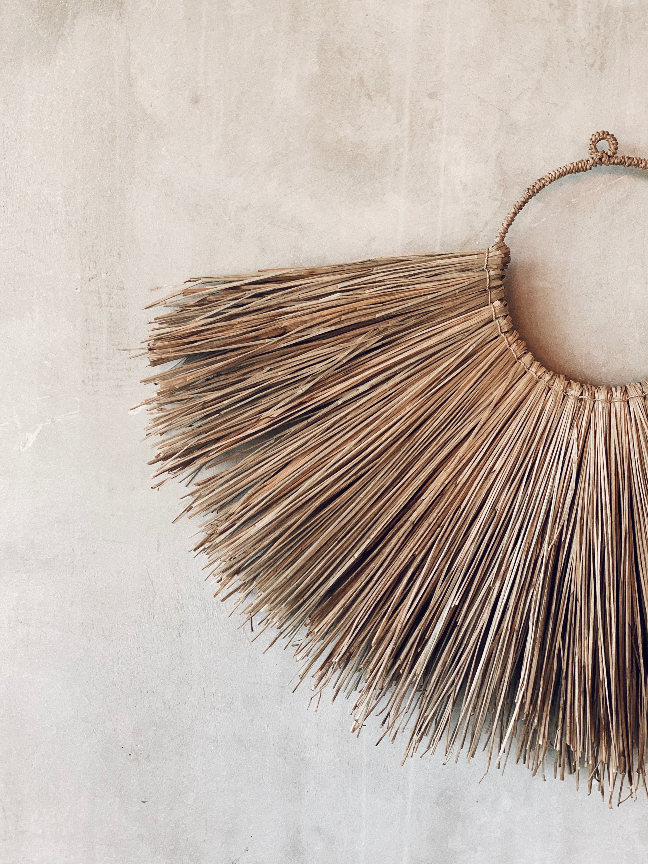 Jingga Allang wall decoration made of natural grass, showcasing intricate weaving and bohemian style.