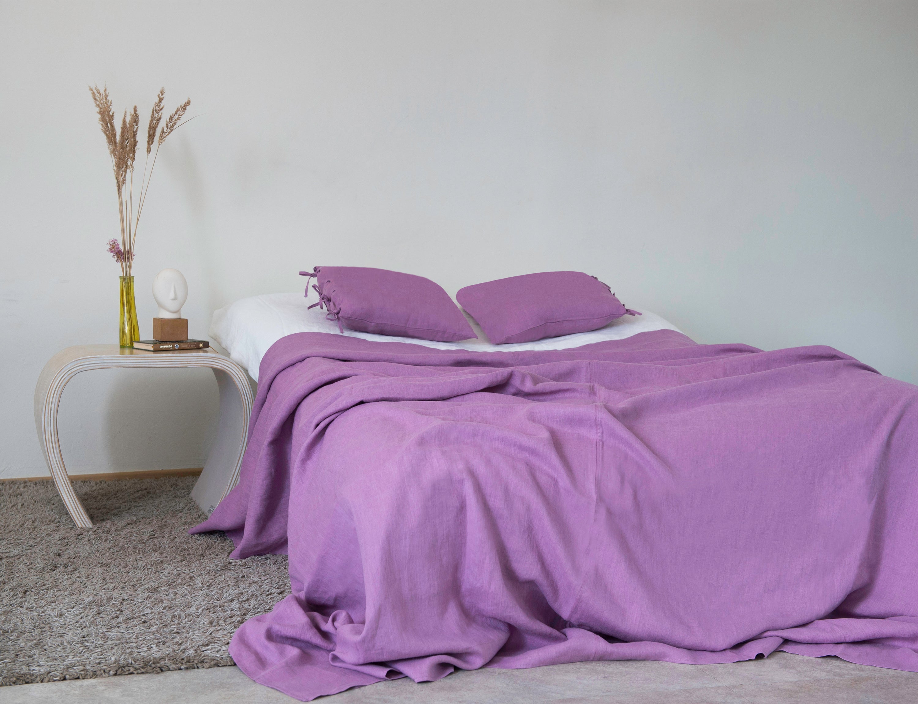 Deep Rose linen bed throw draped elegantly over a couch, showcasing its soft texture and vibrant color.