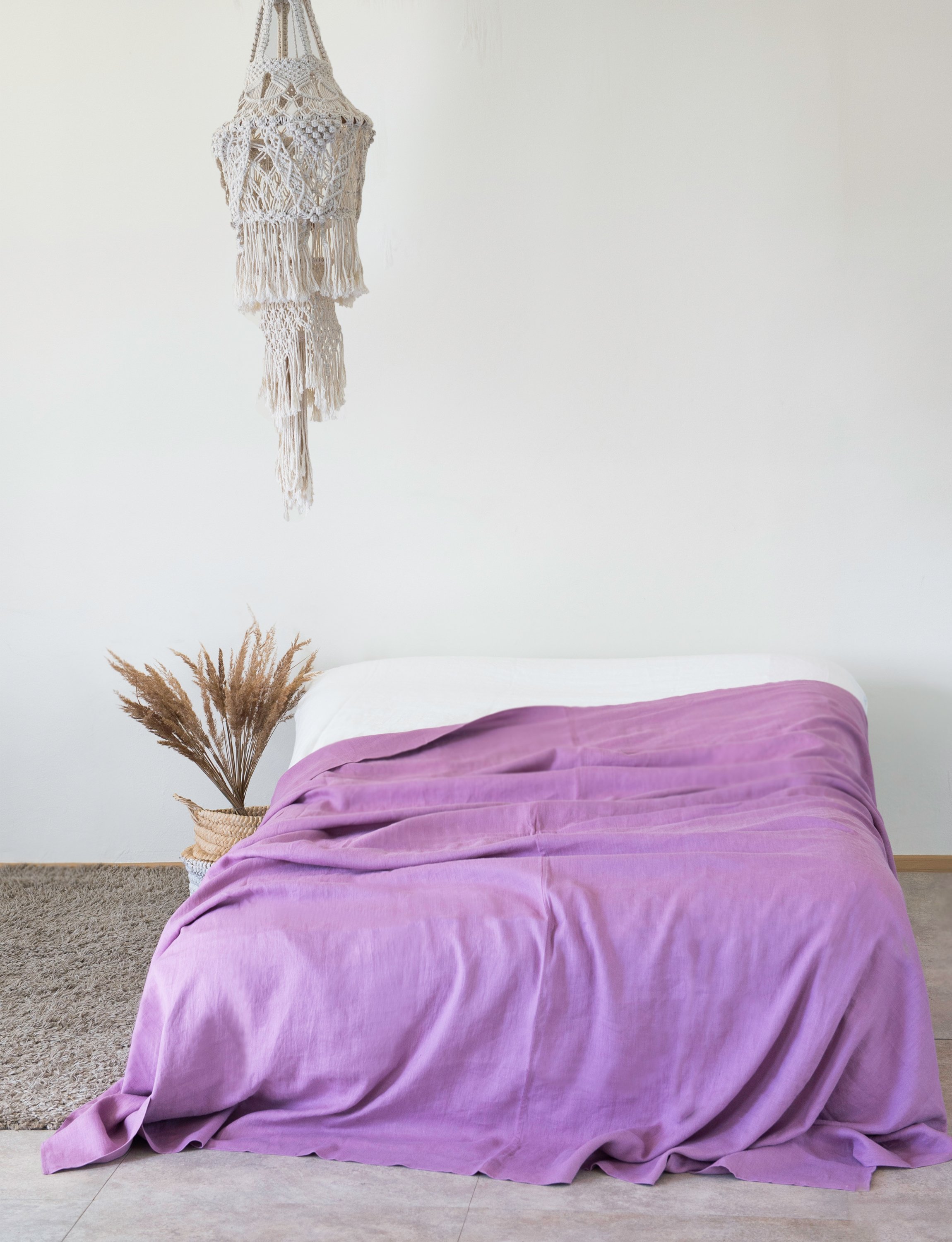 Deep Rose linen bed throw draped elegantly over a couch, showcasing its soft texture and vibrant color.