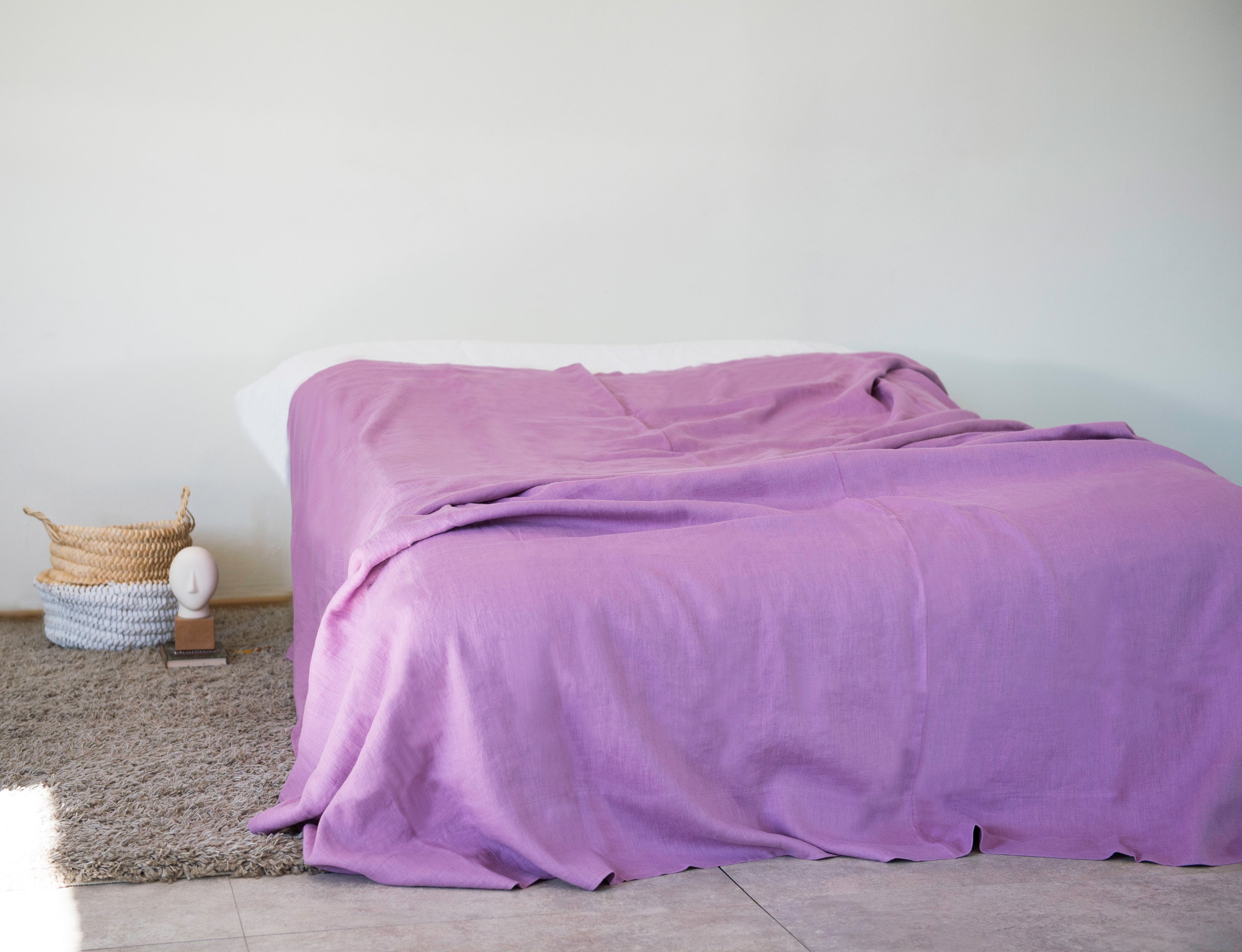 Deep Rose linen bed throw draped elegantly over a couch, showcasing its soft texture and vibrant color.