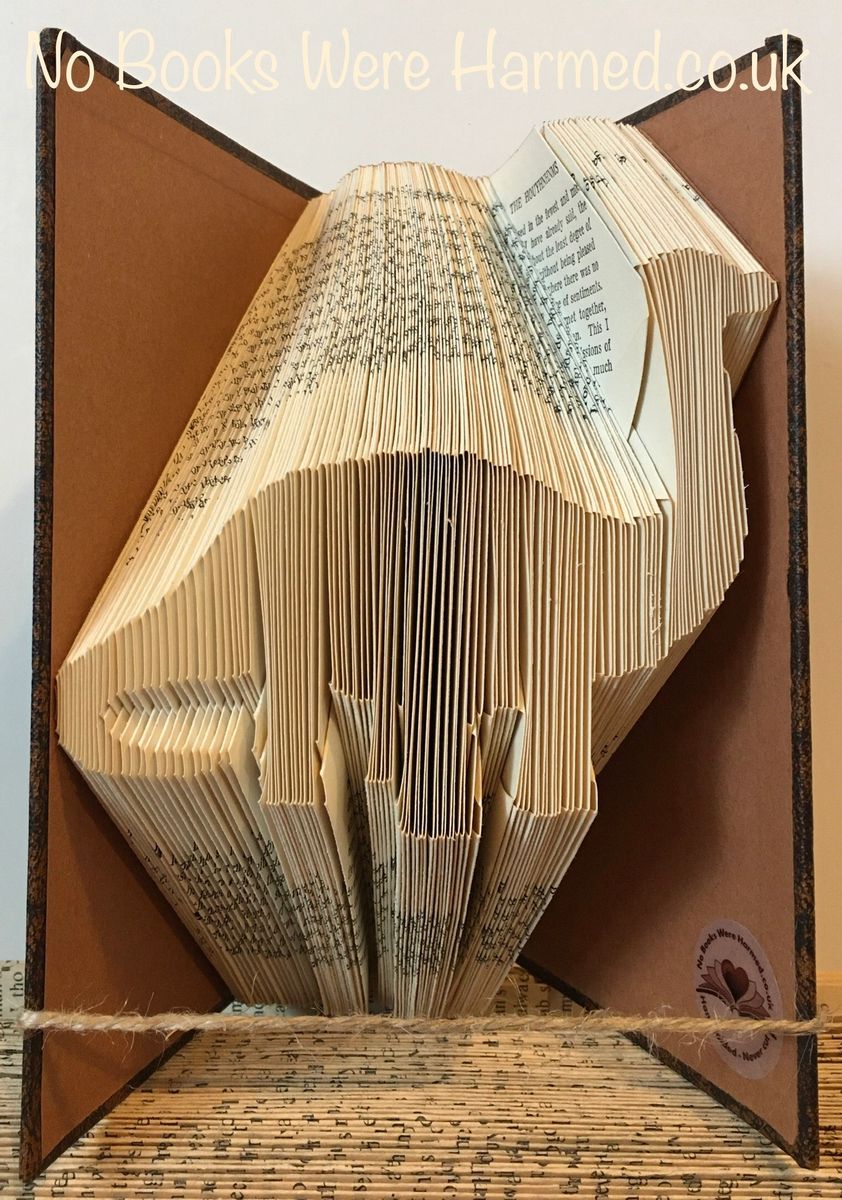 Handcrafted dinosaur art made from vintage book pages, showcasing intricate folds and unique colors.