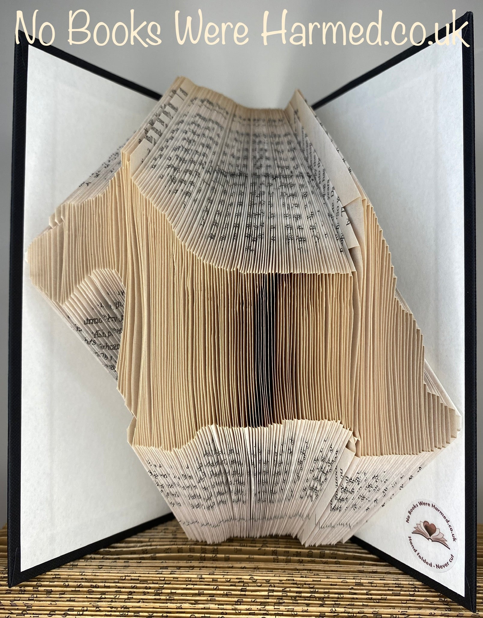 Handcrafted dog silhouette art made from vintage book pages, showcasing intricate details and unique designs.