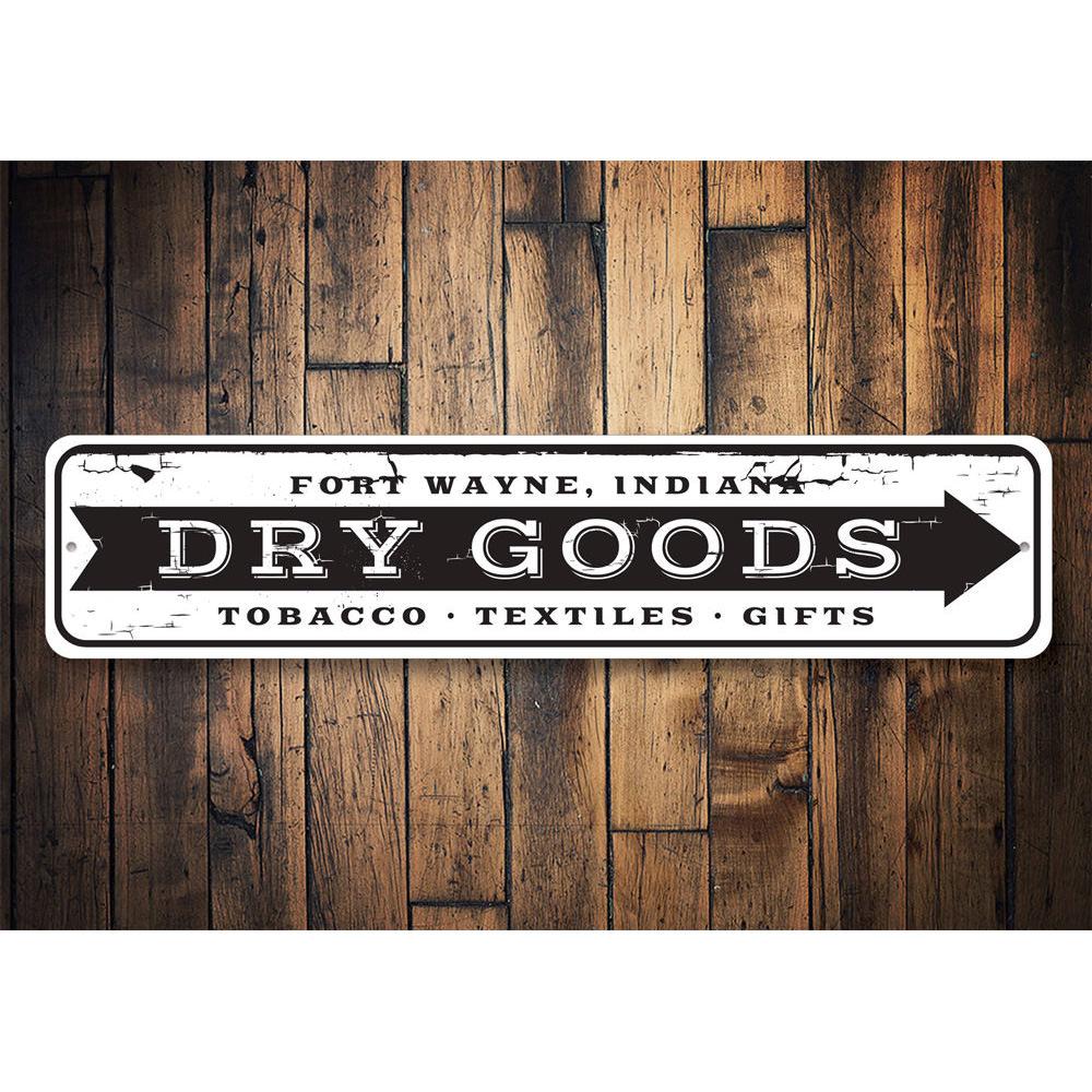 A decorative Dry Goods Arrow Sign made of high-quality aluminum, featuring customizable text and pre-drilled holes for easy mounting.