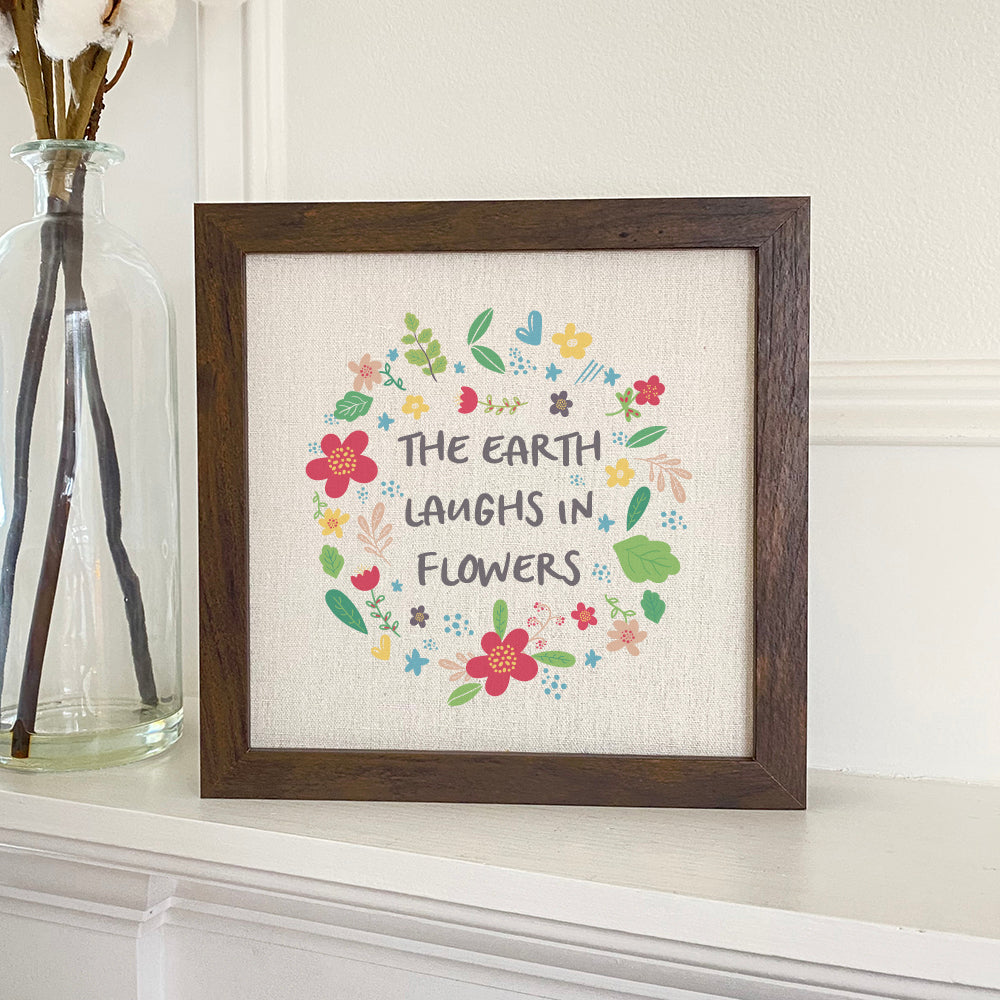 Earth Laughs in Flowers framed sign with a stylized wood frame, featuring eco-friendly ink printing on a linen-look background.