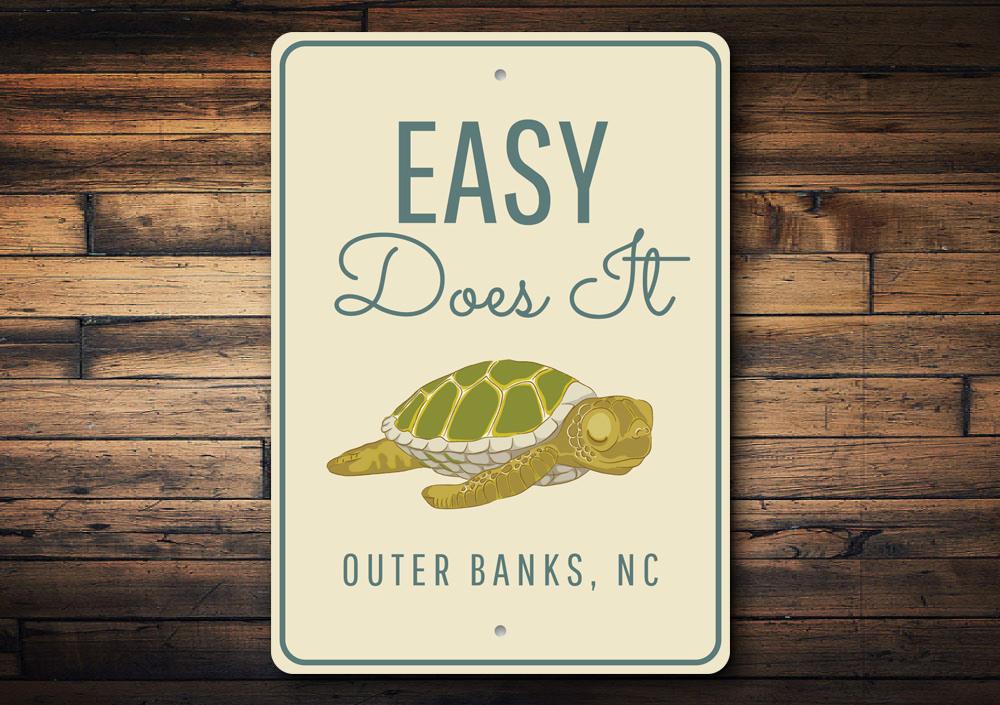 A decorative Easy Does It Sign made of high-quality aluminum, featuring a beach-themed design, perfect for coastal decor.