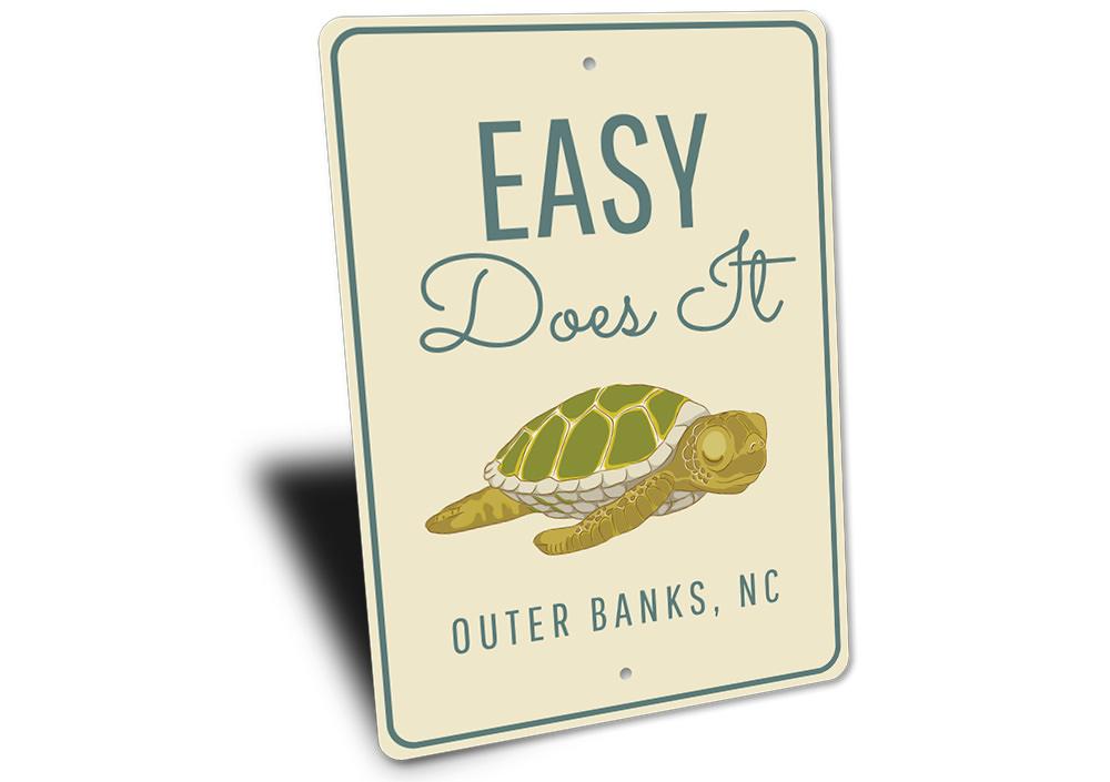 A decorative Easy Does It Sign made of high-quality aluminum, featuring a beach-themed design, perfect for coastal decor.