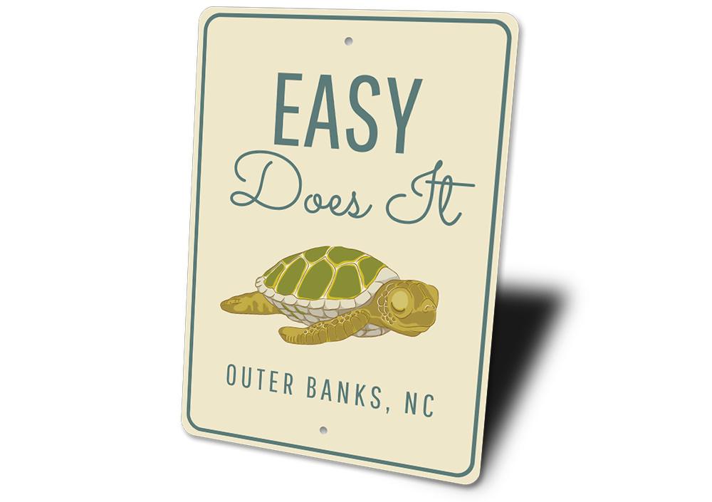 A decorative Easy Does It Sign made of high-quality aluminum, featuring a beach-themed design, perfect for coastal decor.