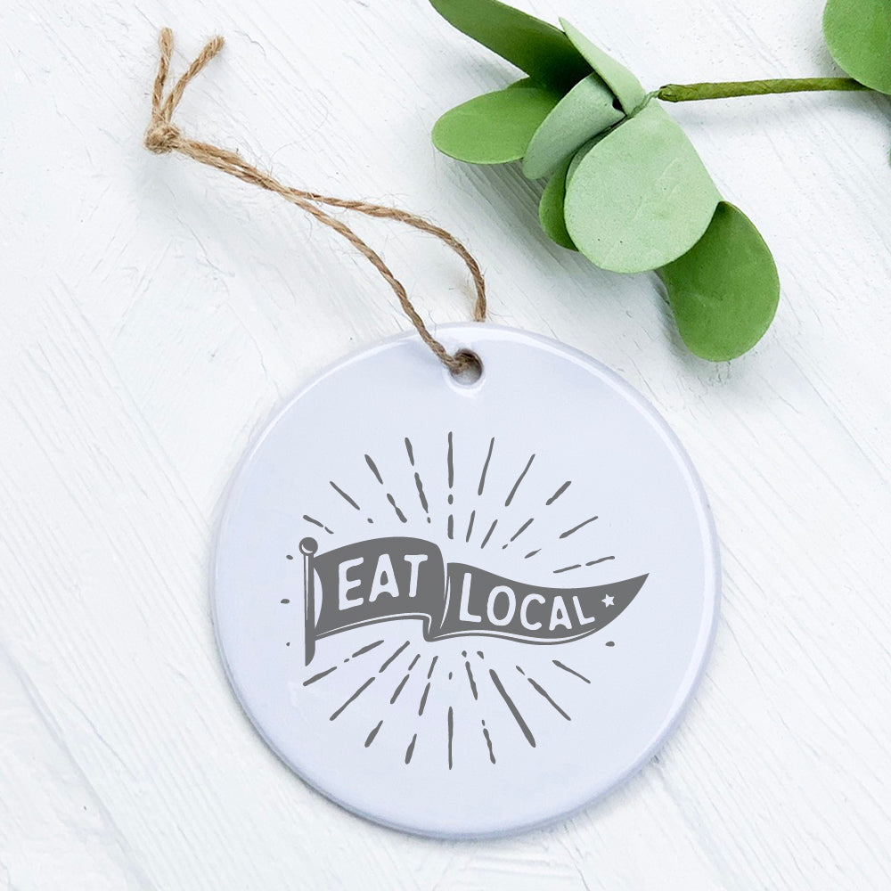 A beautifully crafted Eat Local porcelain ornament featuring original designs from rural Wisconsin, showcasing its smooth gloss finish.