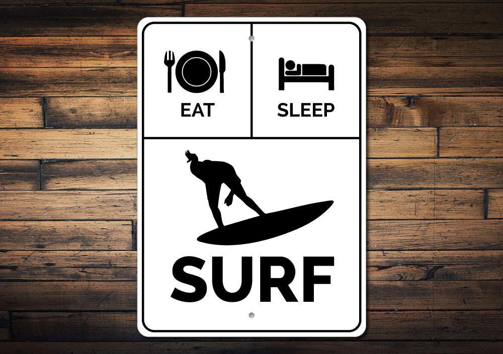 A decorative Eat Sleep Surf Sign made of high-quality aluminum, featuring vibrant colors and a beach-themed design, perfect for coastal decor.