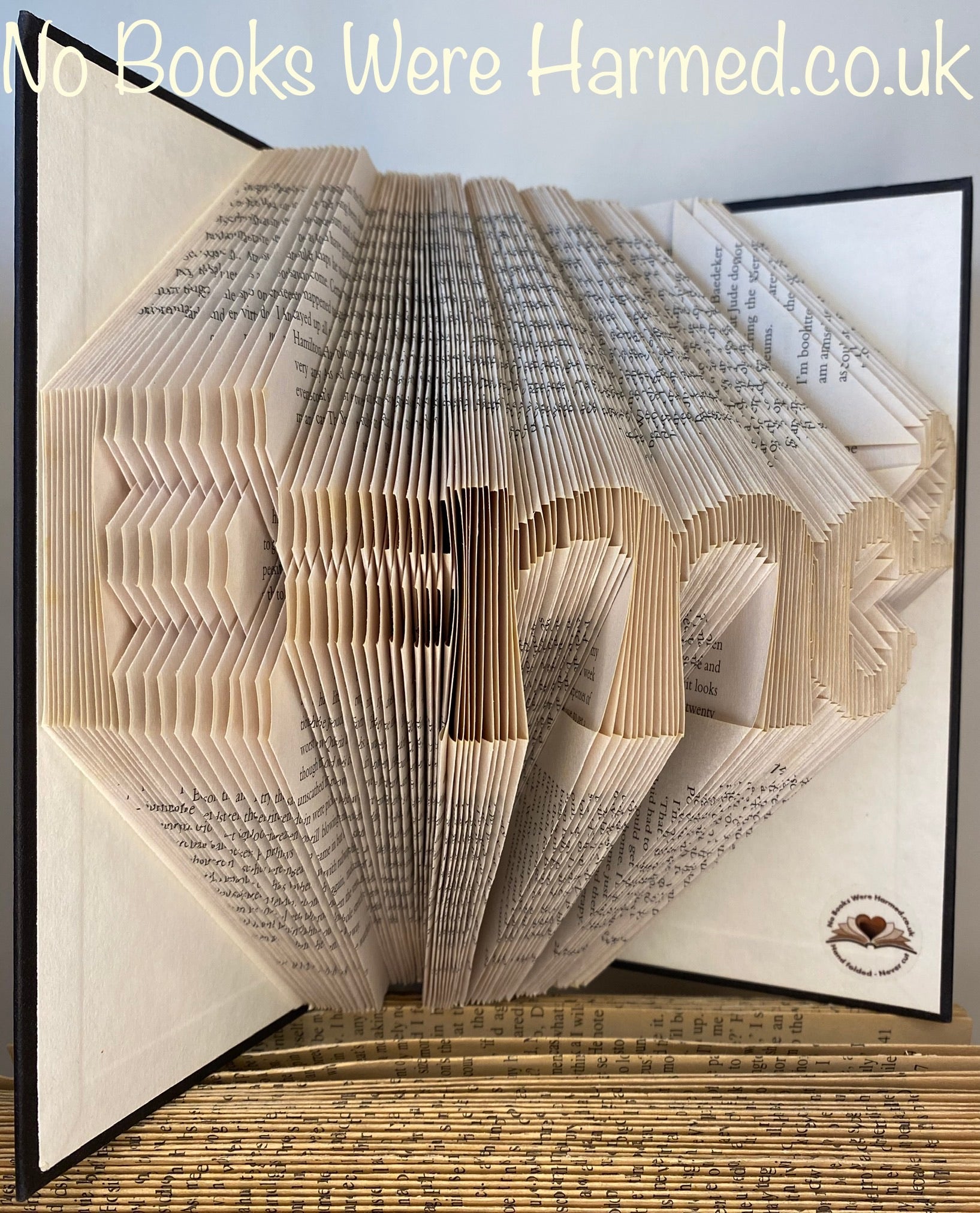 Handcrafted E=mc2 book art made from vintage books, showcasing intricate page folds and unique design.