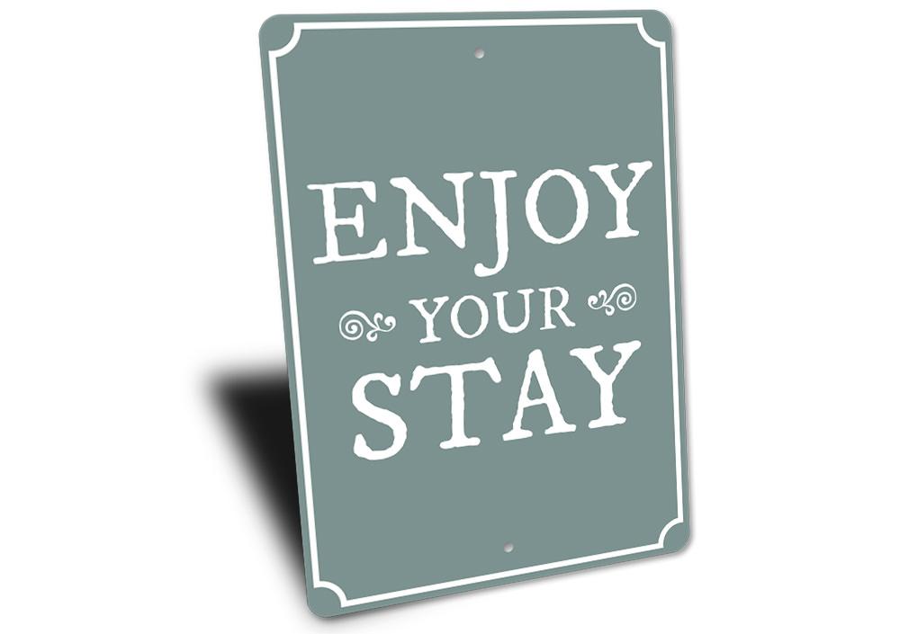 A decorative Enjoy Your Stay Sign made from high-quality aluminum, featuring customizable text and pre-drilled holes for easy mounting.