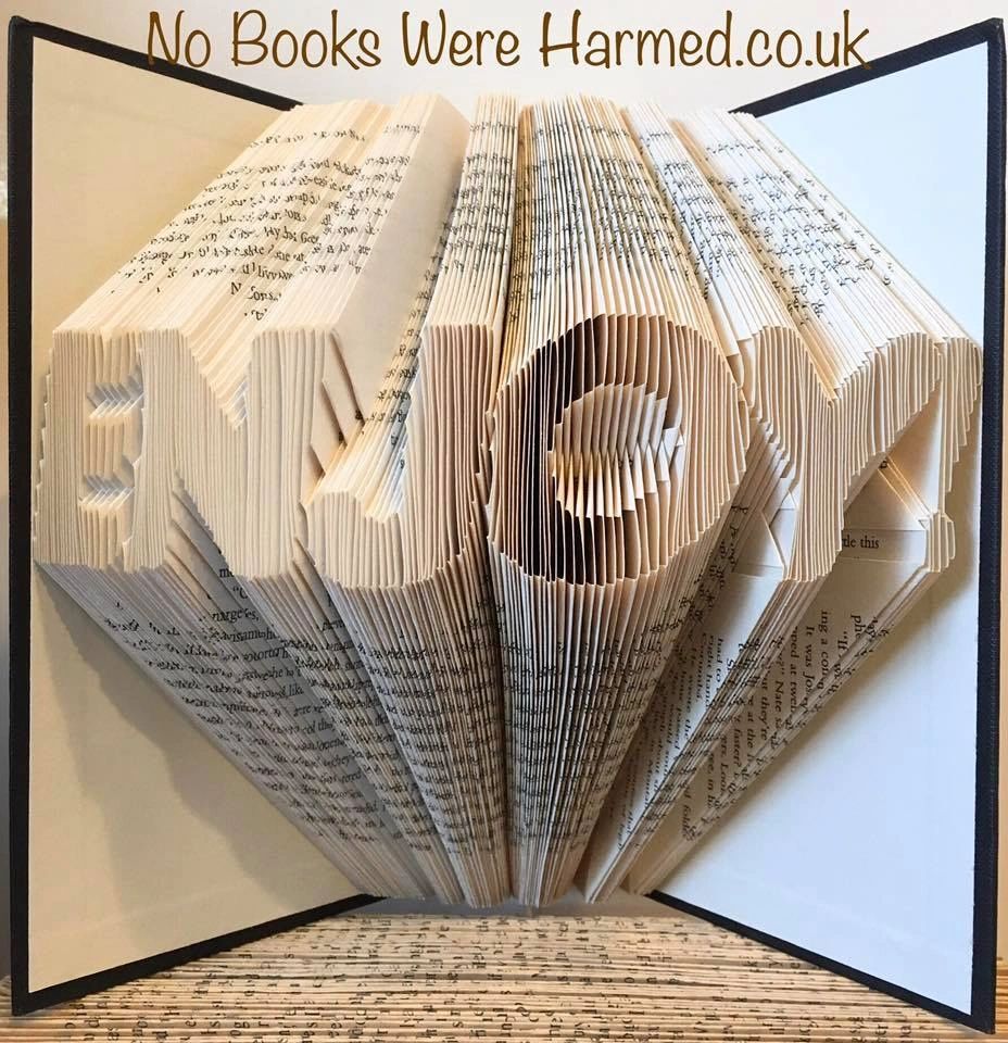 A beautifully crafted hand-folded book art piece made from vintage books, showcasing intricate designs and unique colors.