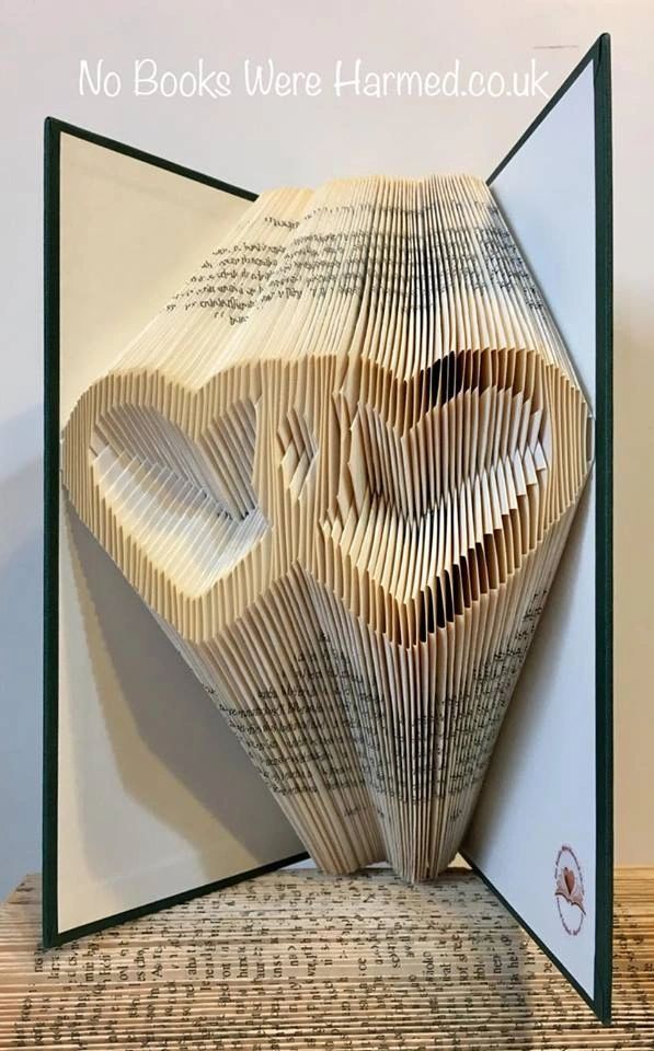 A beautifully crafted entwined love hearts art piece made from vintage book pages, showcasing intricate hand-folded designs.