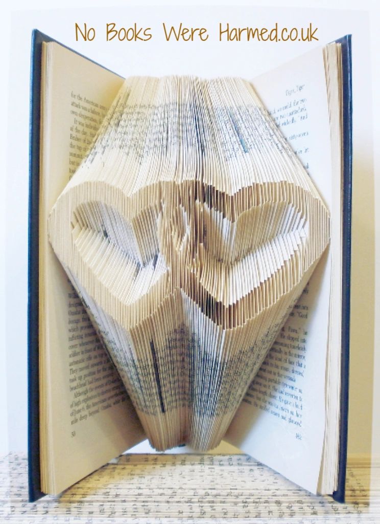 A beautifully crafted entwined love hearts art piece made from vintage book pages, showcasing intricate hand-folded designs.