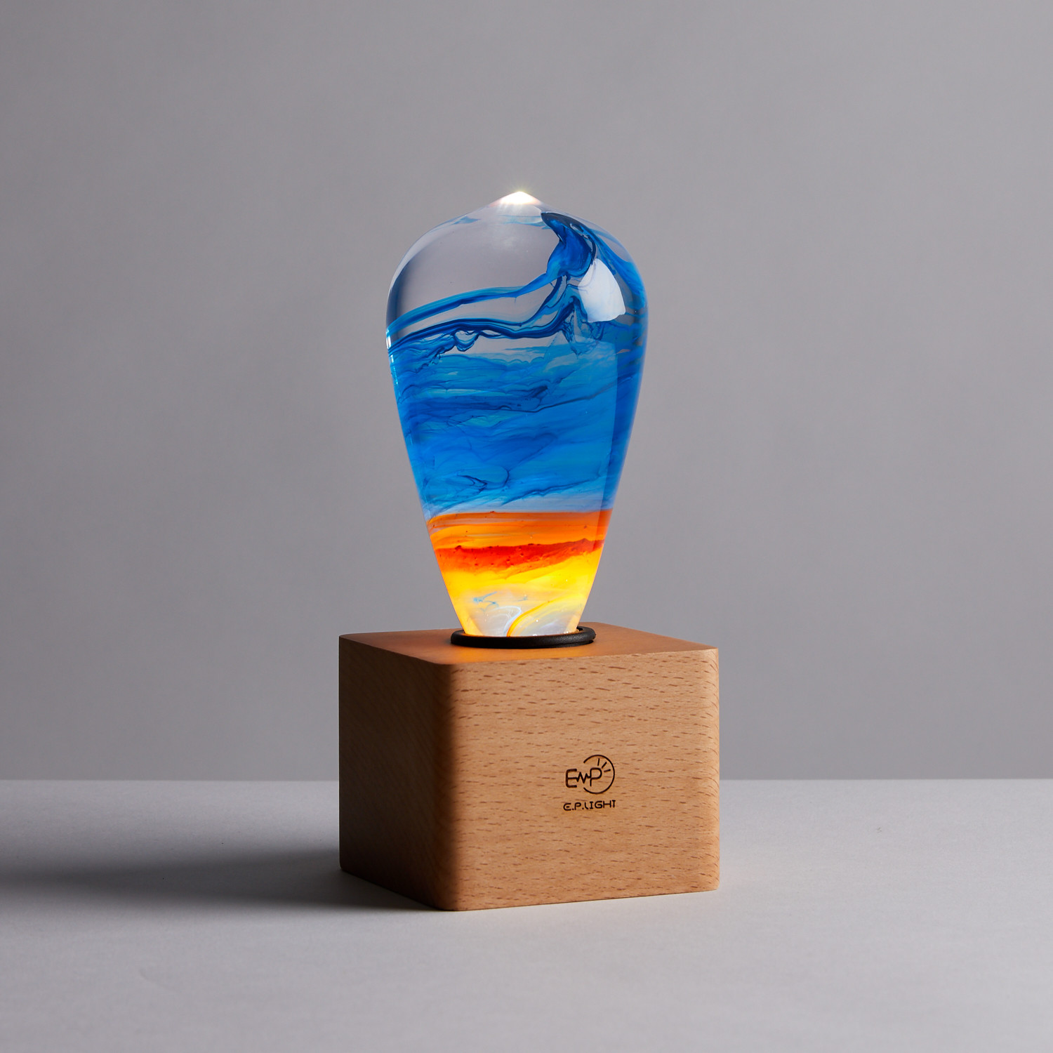 EP Light - Fire LED bulb with mixed colors and a handcrafted design, showcasing eco-friendly materials and a stylish beech wood base.