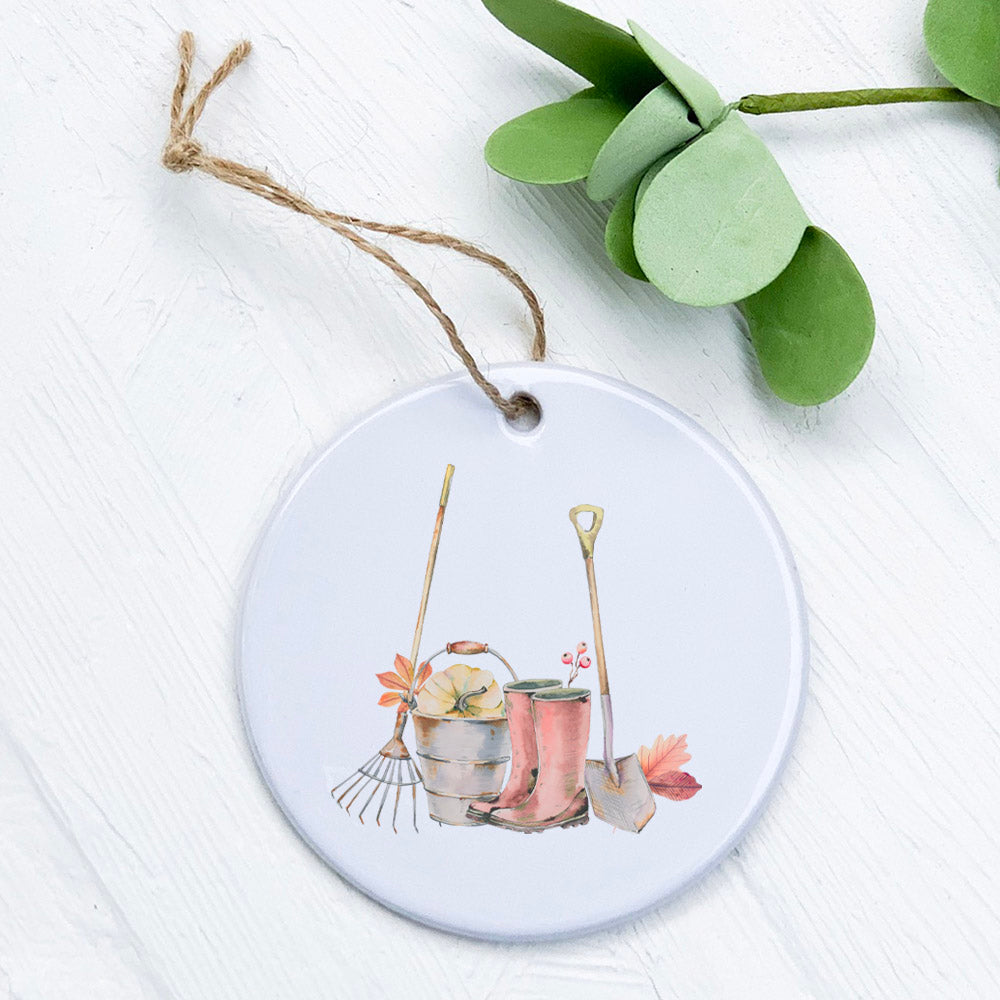 A beautifully crafted porcelain ornament featuring fall boots and garden tools design, perfect for seasonal decor or as a gift tag.