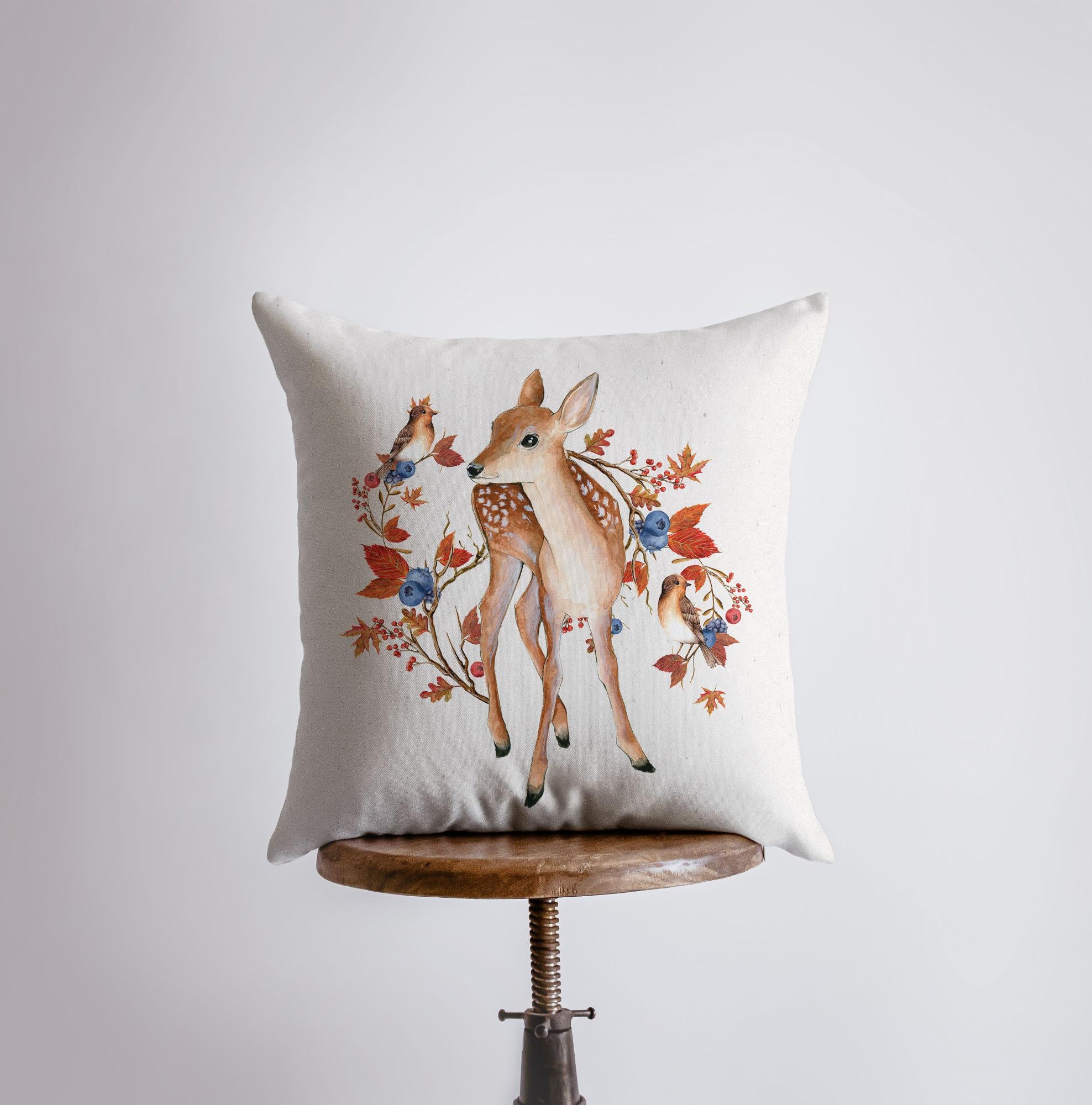 Fall Fawn Deer Looking Left Pillow Cover featuring a beige background with autumn leaves, blueberries, and a fawn, ideal for rustic decor.