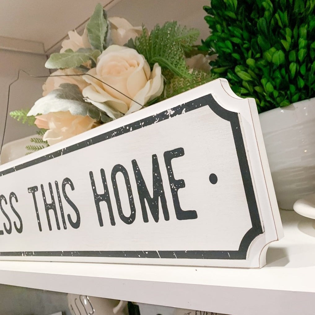 Farmhouse Chic hanging wood sign with 'Bless This Home' and 'Eat Good Food' messages, featuring a rustic white and black design.