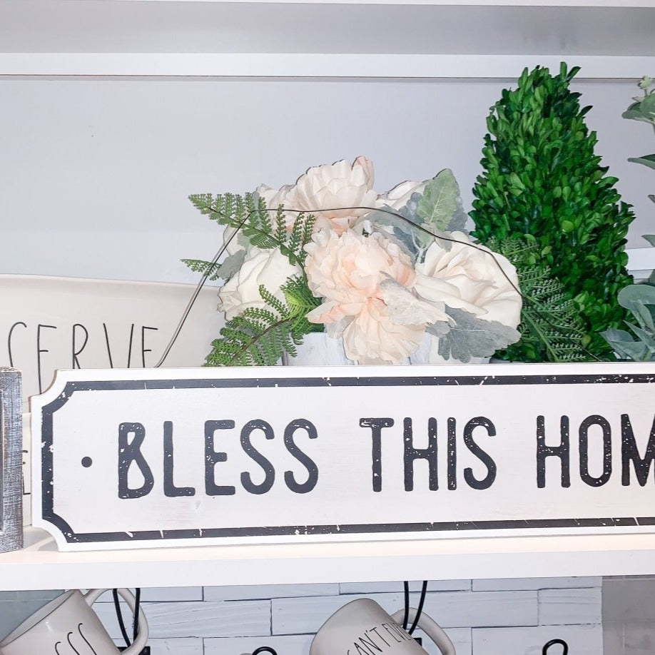 Farmhouse Chic hanging wood sign with 'Bless This Home' and 'Eat Good Food' messages, featuring a rustic white and black design.