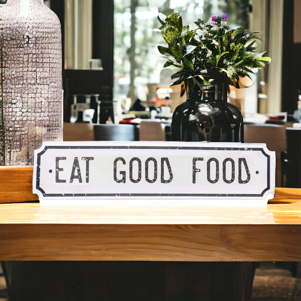 Farmhouse Chic hanging wood sign with 'Bless This Home' and 'Eat Good Food' messages, featuring a rustic white and black design.