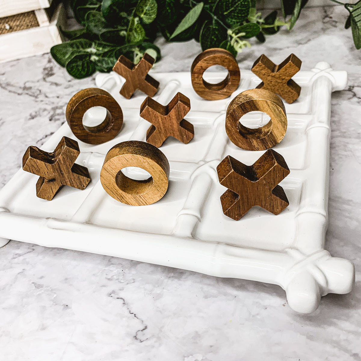 Faux Bamboo Tic Tac Toe game featuring a ceramic board and acacia wood pieces, elegantly designed for decor and play.