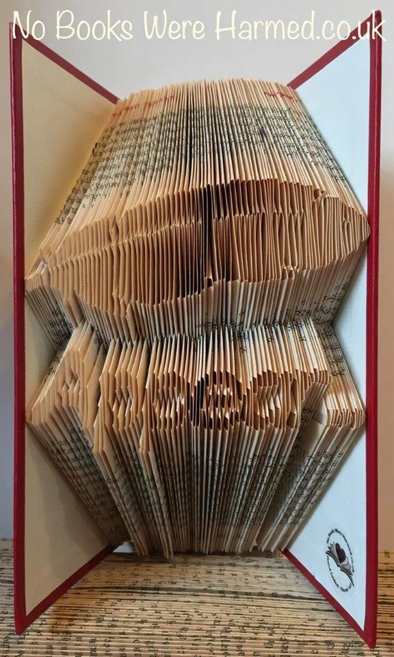 Hand-folded feather art made from vintage book pages, showcasing unique colors and textures.