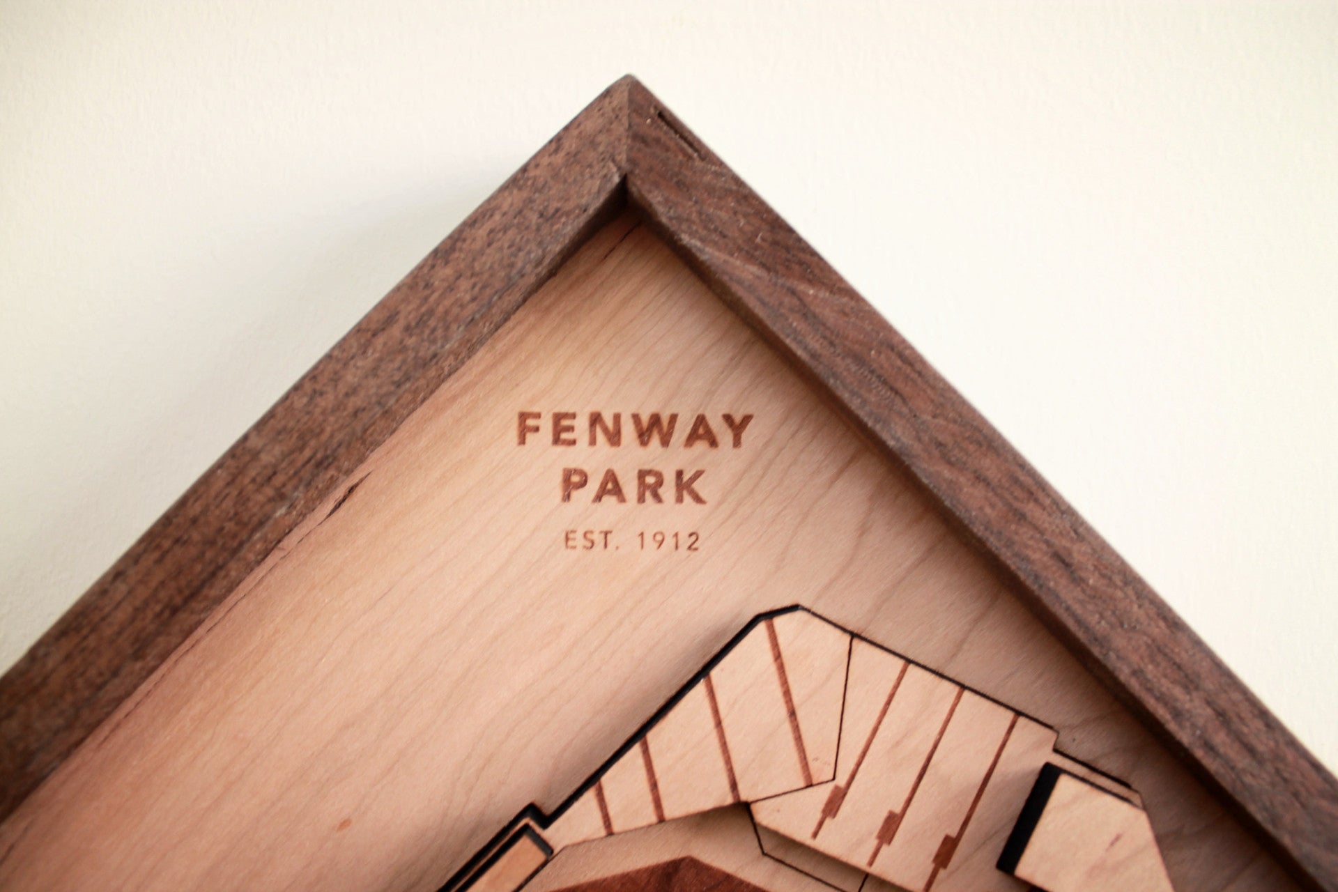 A beautifully crafted replica of Fenway Park, showcasing iconic features like the Green Monster and foul poles, framed in black walnut.