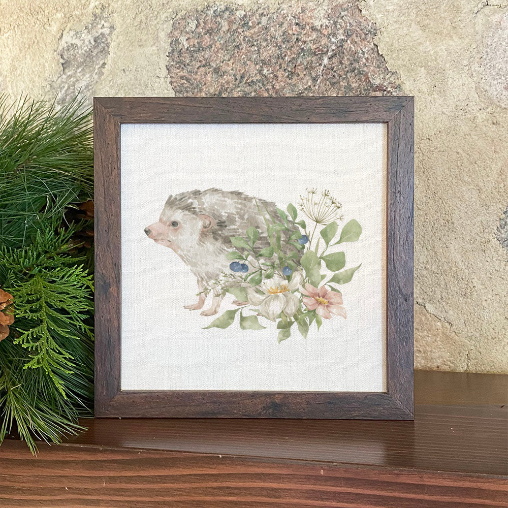 A charming Floral Hedgehog framed sign with a natural wood frame and linen-look background, perfect for home decor.