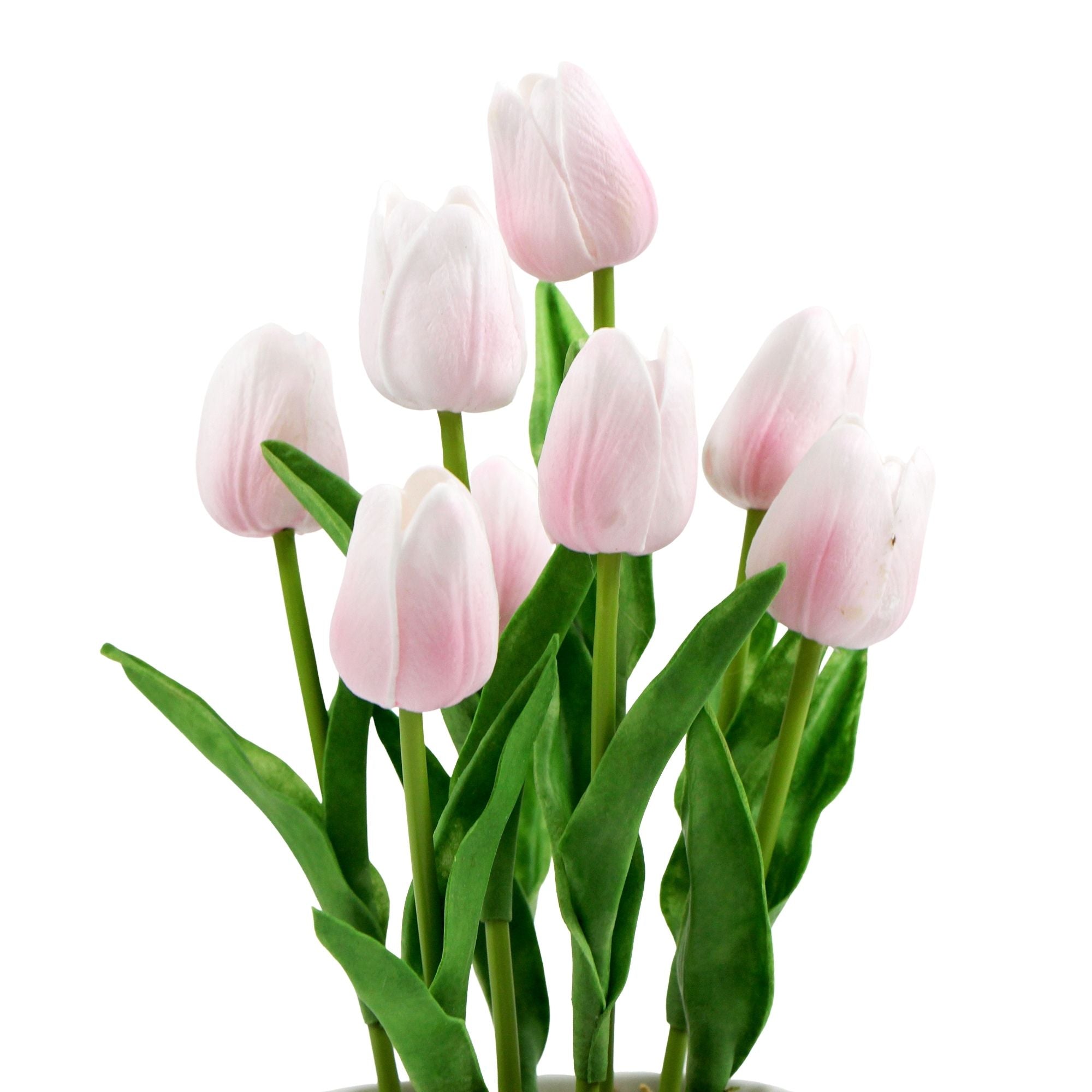 A vibrant arrangement of pink artificial tulips in a modern ceramic bowl, showcasing lush green foliage.