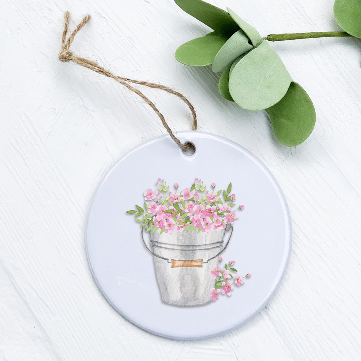 A beautifully crafted porcelain ornament featuring a floral design in a pail, showcasing vibrant colors and a glossy finish.