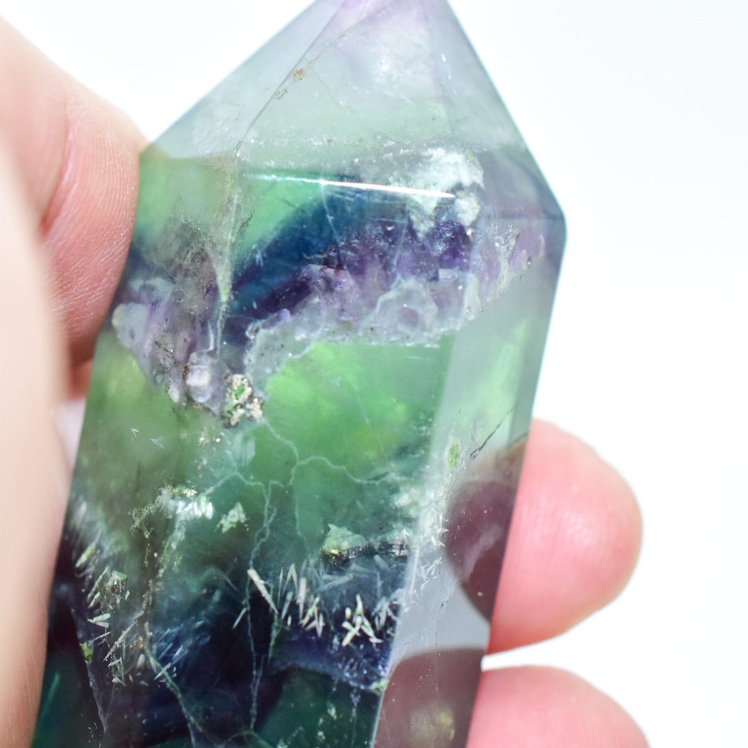 A polished Fluorite Crystal Gemstone Point, showcasing vibrant colors and unique patterns, ideal for energy cleansing and spiritual enhancement.