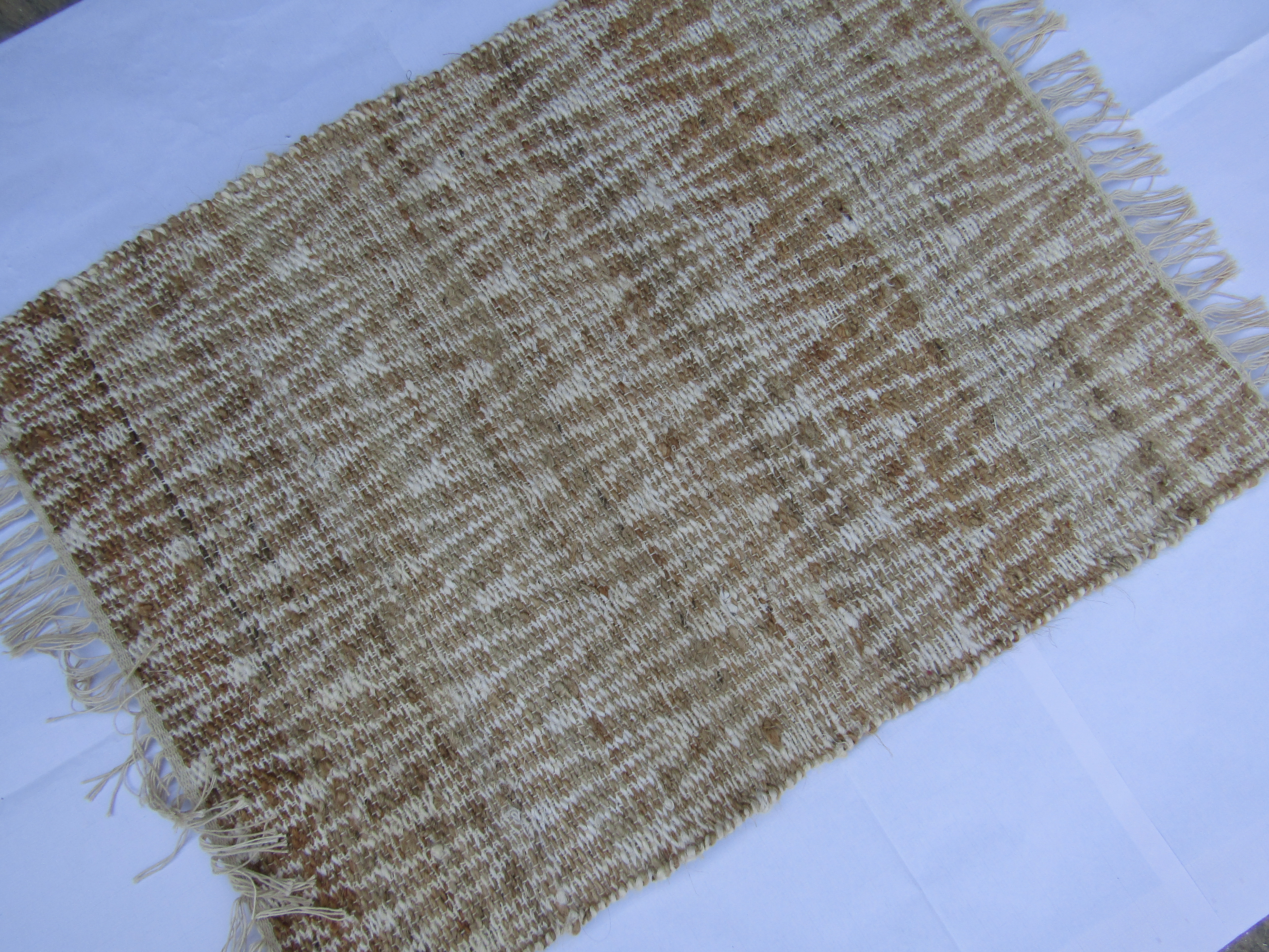 Handwoven beige and white rug.