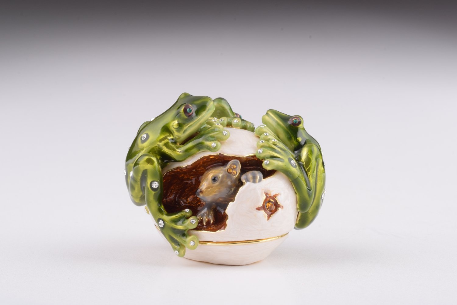 Handmade trinket box featuring frogs on a white egg, adorned with Austrian crystals and 24K gold plating, with a hidden mouse design.