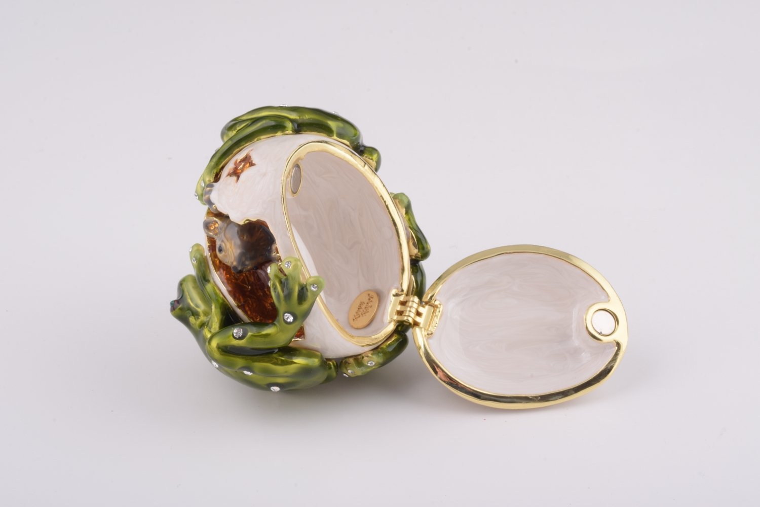 Handmade trinket box featuring frogs on a white egg, adorned with Austrian crystals and 24K gold plating, with a hidden mouse design.