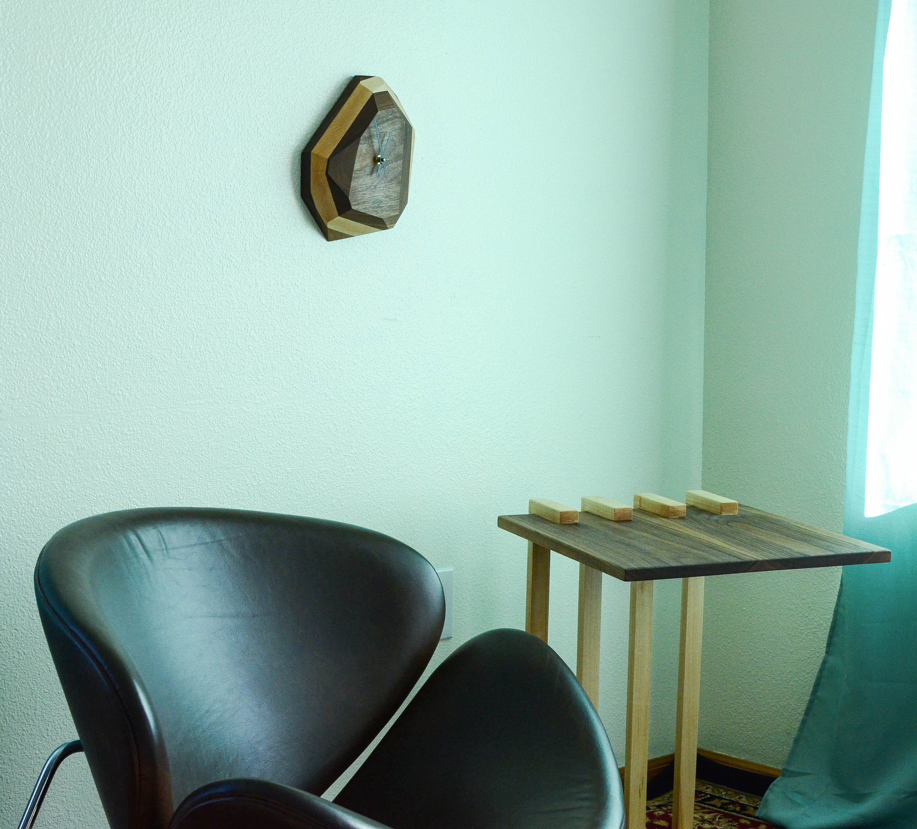 A modern geometric wall and table clock made from American hardwood, showcasing unique wood grain patterns and a quartz crystal-inspired design.