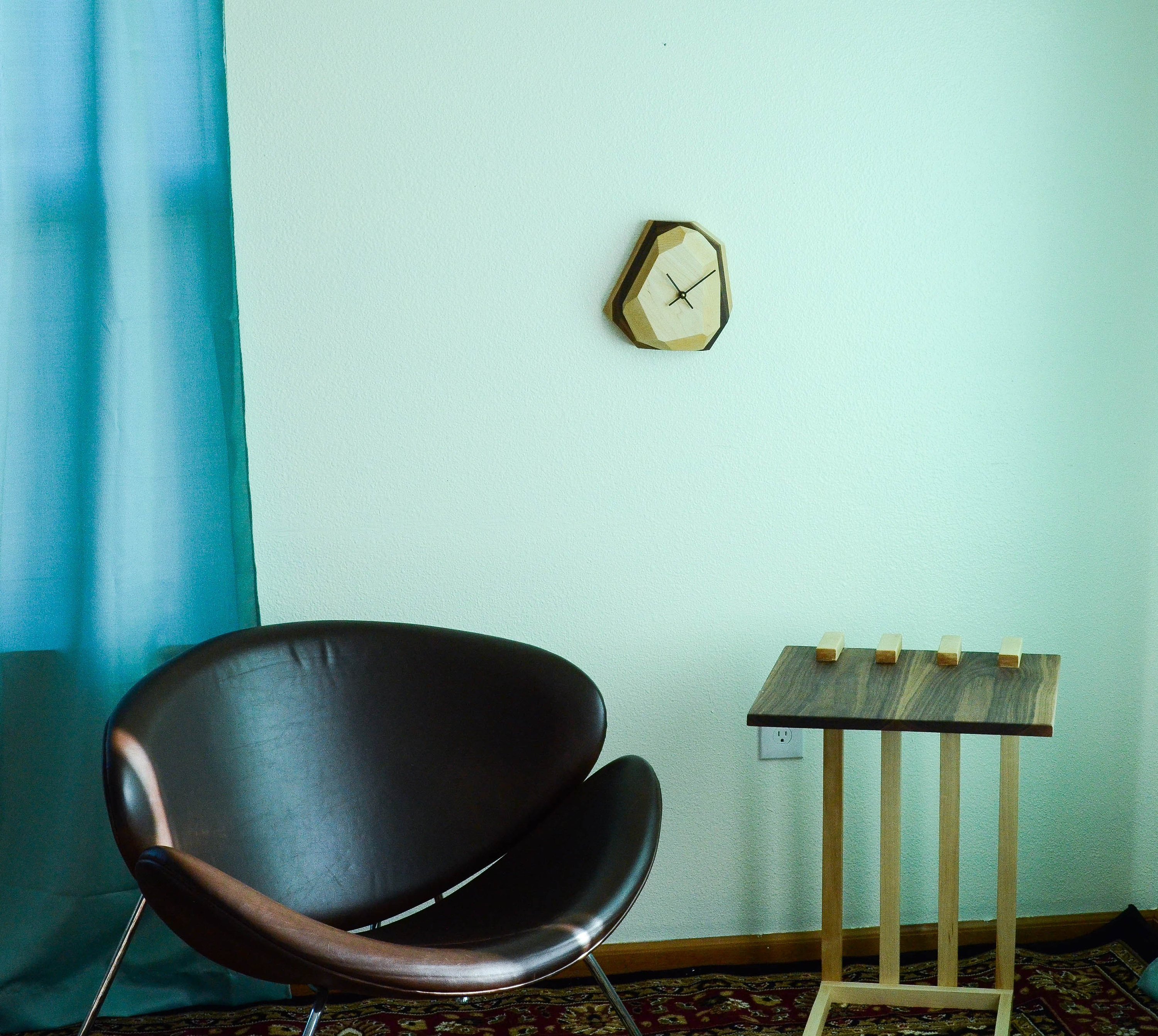 A modern geometric wall and table clock made from American hardwood, showcasing unique wood grain patterns and a quartz crystal-inspired design.