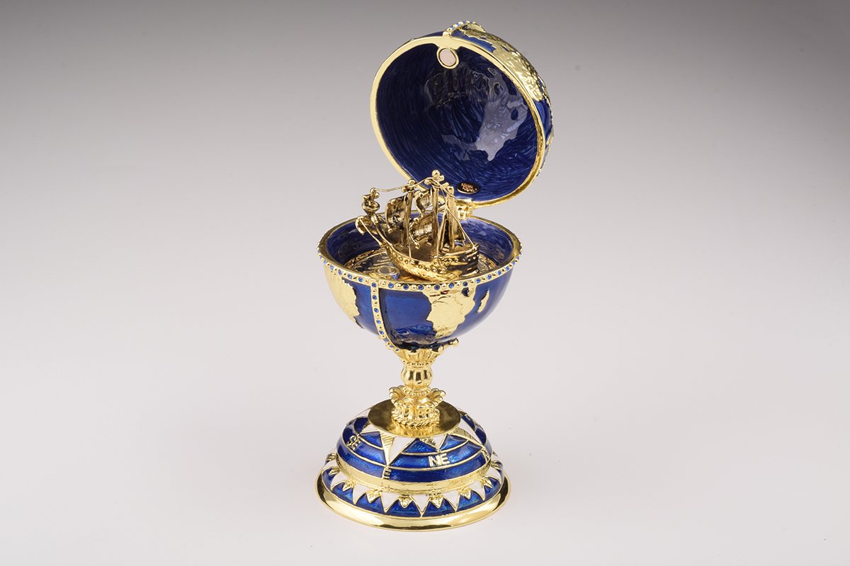 A beautifully crafted Globe Faberge Egg trinket box featuring a sailing ship design, adorned with Austrian crystals and plated in 24K gold or 925 silver.